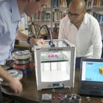 researchers setting up a 3D printer